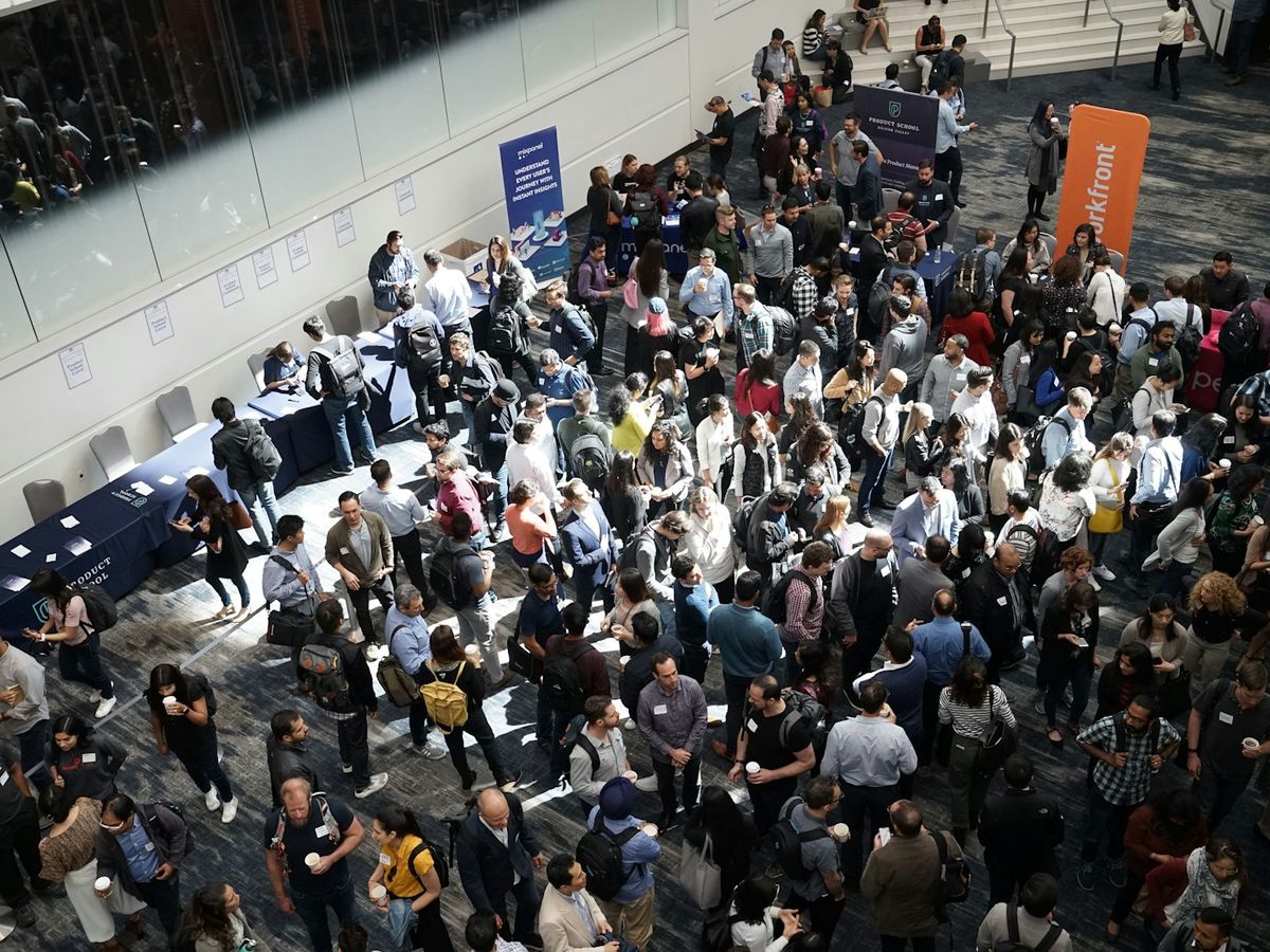 A large crowd of attendees networking in a conference lobby